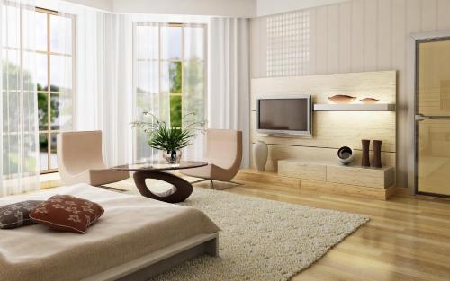 a living room with a bed and a television at MAISON CHAMA in Tiko