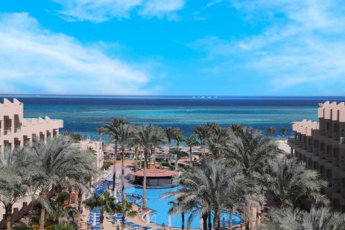 Blick auf ein Resort mit Palmen und das Meer in der Unterkunft Sea Star Beau Rivage Hotel in Hurghada
