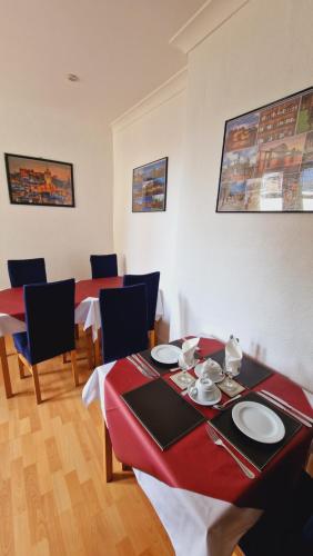 jadalnia z 2 stołami i krzesłami z czerwoną tkaniną w obiekcie Mackenzie Guest house w Edynburgu