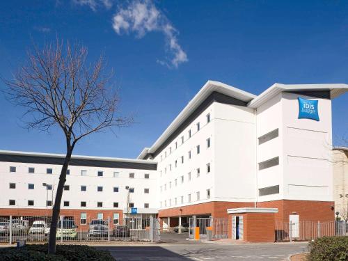 a large white building with a blue sign on it at ibis budget Cardiff Centre in Cardiff