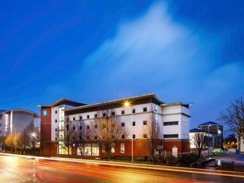 a building on the side of a street at night at ibis budget Cardiff Centre in Cardiff