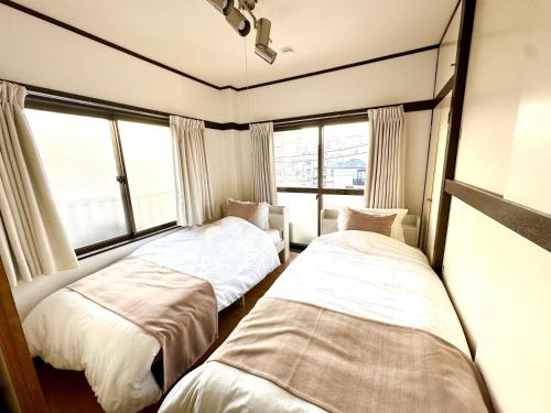 two beds in a room with two windows at 2名様におすすめ 山手駒込駅徒歩3分 Switch付き池袋新宿秋葉原上野浅草渋谷 in Tokyo
