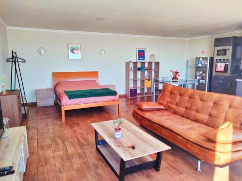 a living room with a couch and a bed at Studio a Casa Valentina in Estreito da Calheta