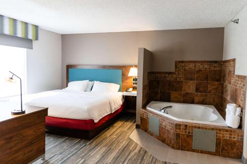 um quarto de hotel com uma cama e uma banheira em Hampton Inn & Suites Scottsbluff em Scottsbluff