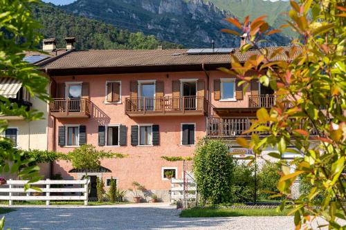 a large red brick building with a white fence at Ledro Lake Suite "Pur" in Mezzolago