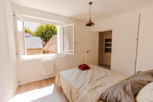 1 dormitorio con cama y ventana en Bel appartement 35 m 1er étage, en Évaux-les-Bains