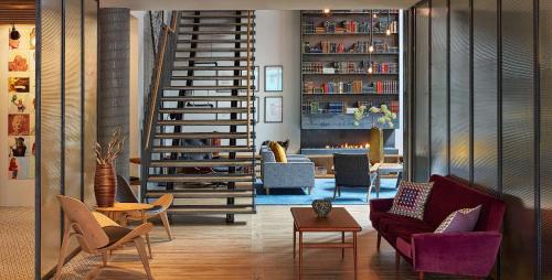 a living room with a spiral staircase and a fireplace at Canopy by Hilton Reykjavik City Centre in Reykjavík