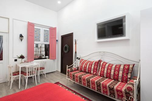 a living room with a couch and a tv on a wall at Studio in Old Tbilisi, Prime location, King Size Bed, AC, Heating in Tbilisi City