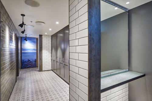 a walk in shower in a bathroom with white tiles at Canopy by Hilton Reykjavik City Centre in Reykjavík