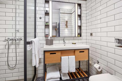 a bathroom with a sink and a mirror at Canopy by Hilton Reykjavik City Centre in Reykjavík