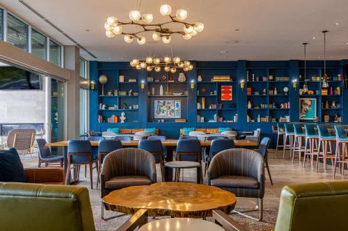 a restaurant with blue walls and tables and chairs at Canopy By Hilton Dallas Uptown in Dallas