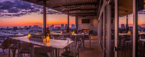 a restaurant with tables and chairs and a view of the city at Canopy By Hilton Dallas Uptown in Dallas
