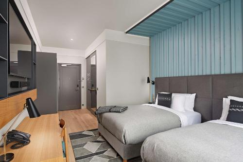 a hotel room with two beds and a kitchen at Canopy by Hilton Reykjavik City Centre in Reykjavík