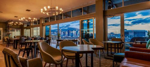 a restaurant with tables and chairs and a view of the city at Canopy By Hilton Dallas Uptown in Dallas