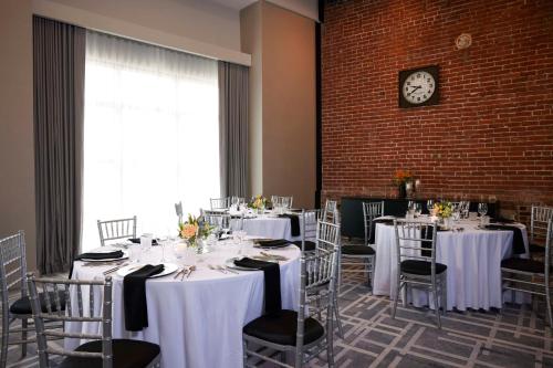 a room with tables and chairs with a clock on the wall at Canopy By Hilton Columbus Downtown Short North in Columbus