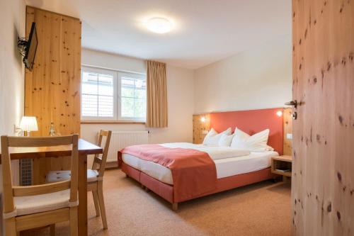 een hotelkamer met een bed en een bureau bij Bachäckerhof - Nichtraucherhotel- in Ravensburg