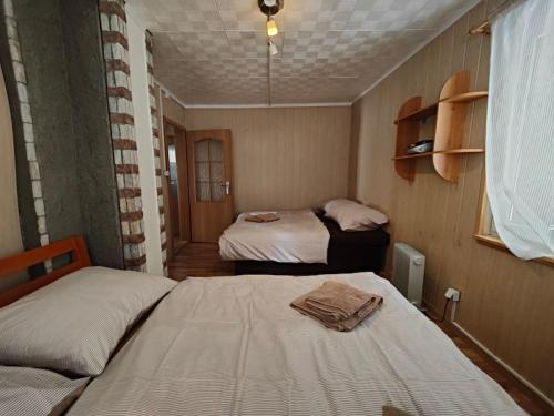 ein kleines Zimmer mit 2 Betten und einem Fenster in der Unterkunft Chata na Poľane in Hriňová