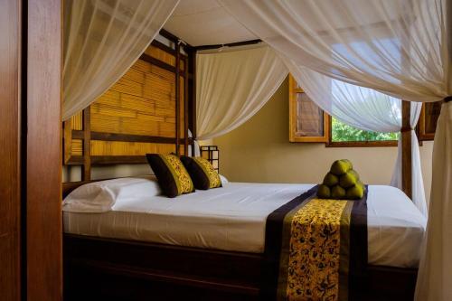 a bedroom with a bed with curtains and fruit on it at Masía Durbá Hotel in Castellnovo