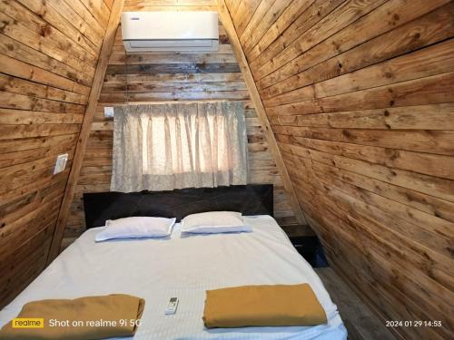 una camera con un letto in una cabina di legno di Lord Sunrise- Shanker Farm Villa a Kīhīm