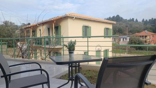 a table and chairs on a balcony with a house at MILIASIA in Kondáraina
