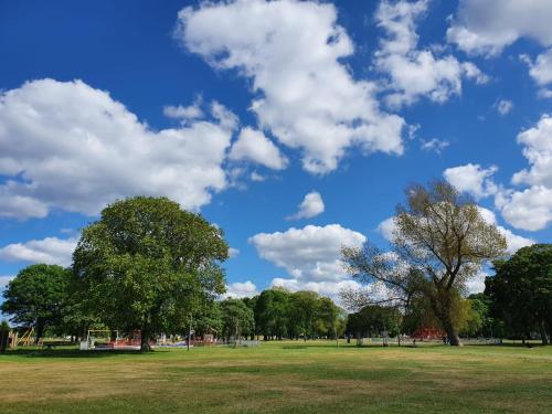 un parque con árboles y un cielo azul con nubes en Mackenzie Guest house, en Edimburgo