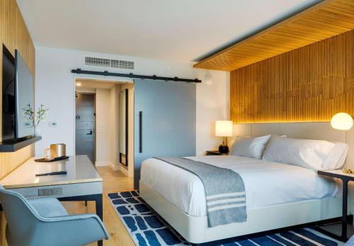 a bedroom with a bed and a desk and a chair at Canopy By Hilton Portland Waterfront in Portland