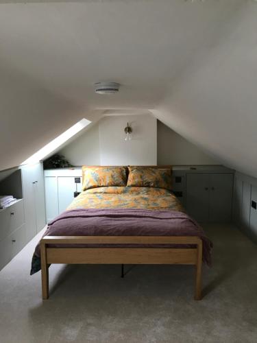 una camera da letto con un letto grande in una mansarda di Rose Cottage, Little Haven a Pembrokeshire