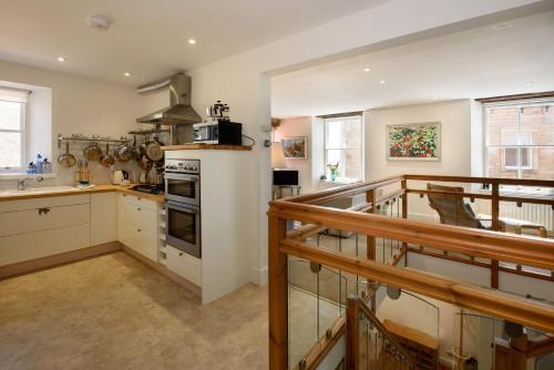 a kitchen with white cabinets and a balcony at House on the Harbour Pittenweem in Pittenweem