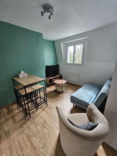 un salon avec un canapé et une table dans l'établissement L'émeraude, à Auxerre