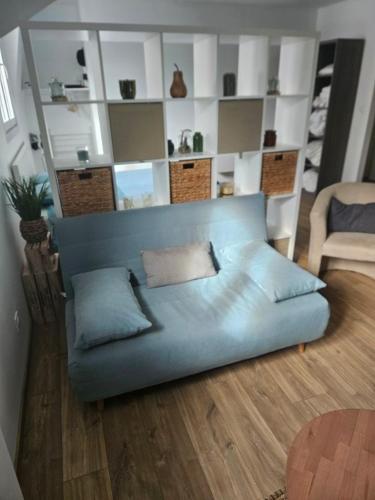 - un canapé bleu dans le salon dans l'établissement L'émeraude, à Auxerre