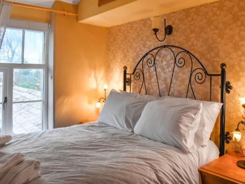 a bedroom with a large bed with white pillows at Beech Cottage in Carnforth