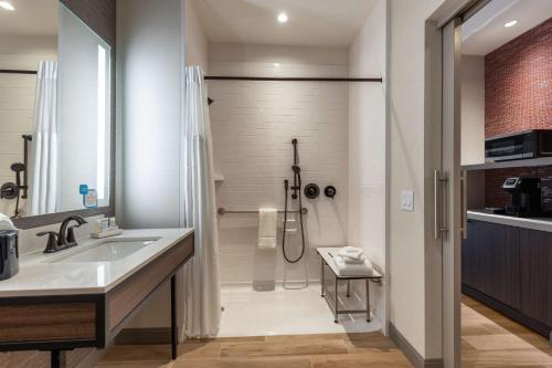 uma casa de banho com um chuveiro, um lavatório e um chuveiro em Hilton Garden Inn- Chicago Central Loop em Chicago
