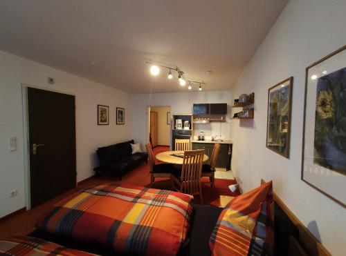ein Wohnzimmer mit einem Bett und einem Tisch in der Unterkunft Ferienwohnung mit Schwimmbad und Gartenblick in Sankt Englmar