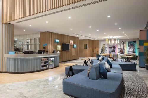 a lobby with blue couches and a waiting room at Hampton by Hilton Antalya Airport in Antalya