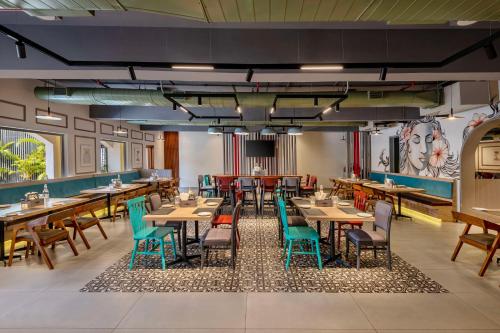 a dining room with wooden tables and chairs at Hyatt Place Goa Candolim in Candolim
