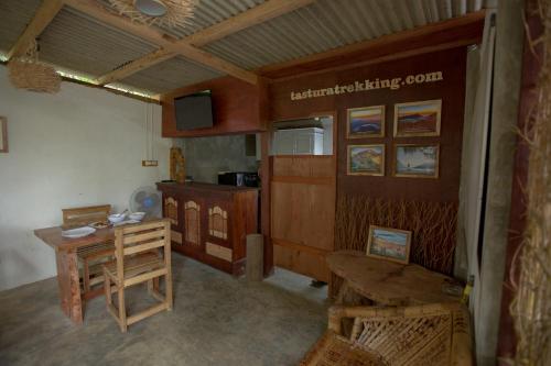 a room with a desk and a table in a room at Tastura Homestay in Praya