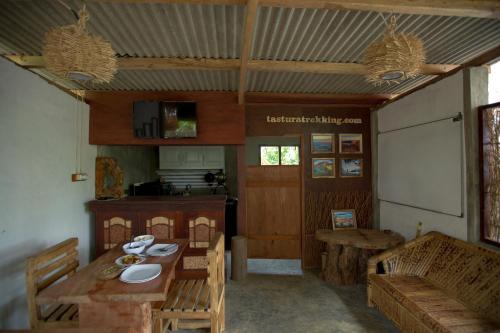 a room with a table and chairs and a kitchen at Tastura Homestay in Praya