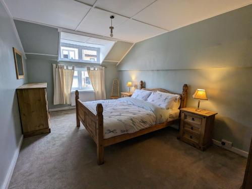 1 dormitorio con 1 cama, 2 mesitas de noche y ventana en The Old Fire House en Thetford