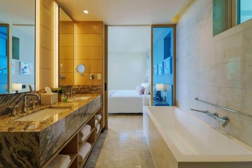 ein Badezimmer mit einer großen Badewanne und einem großen Spiegel in der Unterkunft Wyndham Grand Barbados Sam Lords Castle All Inclusive Resort in Saint Philip