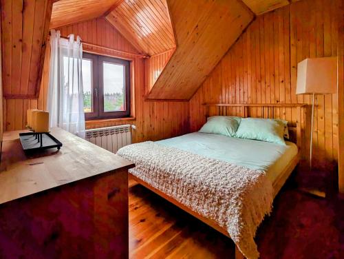 Cama en habitación de madera con ventana en Dom na skarpie z widokiem na jezioro, z kominkiem i garażem, en Stary Dzierzgoń