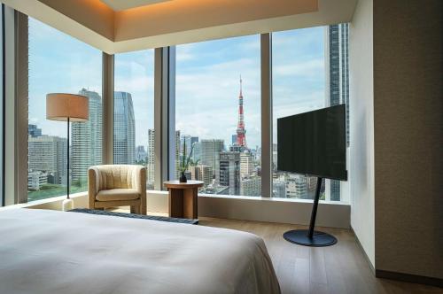 sypialnia z łóżkiem i dużym oknem z telewizorem w obiekcie Hotel Toranomon Hills, The Unbound Collection By Hyatt w Tokio