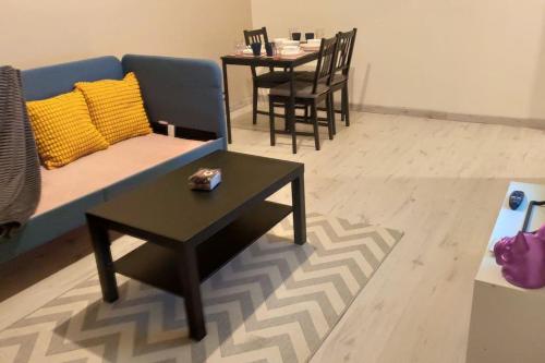 un salon avec un canapé bleu et une table dans l'établissement Charmant appartement proche Melun centre ville, à Melun