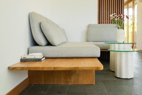 a couch sitting on top of a wooden table at The Birdhouse Uluwatu 2BR Treetop Private Home with Deep Plunge Pool in Uluwatu