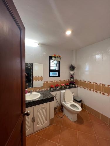 a bathroom with a toilet and a sink at พนาสนธิ์แหลมหินรีสอร์ท in Ban Laem Hin