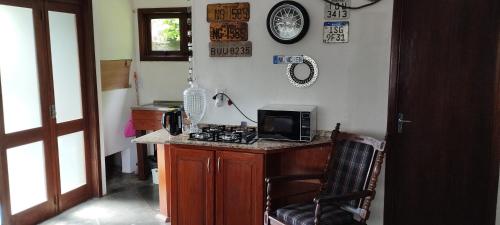 a kitchen with a counter with a microwave and a stove at Recanto do Sossego in Santa Cruz do Sul