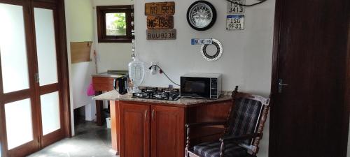 una cucina con piano di lavoro, forno a microonde e piano cottura di Recanto do Sossego- Espaço Jean a Santa Cruz do Sul
