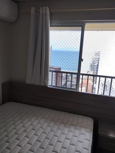 a bedroom with a bed and a large window at Villa damasco in Fortaleza