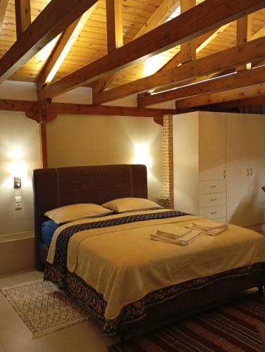 a bedroom with a large bed with wooden ceilings at Anna's Apartment and Studio in Artemida
