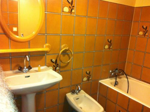 een badkamer met een wastafel, een spiegel en een toilet bij Min Gwenn in Trévou-Tréguignec