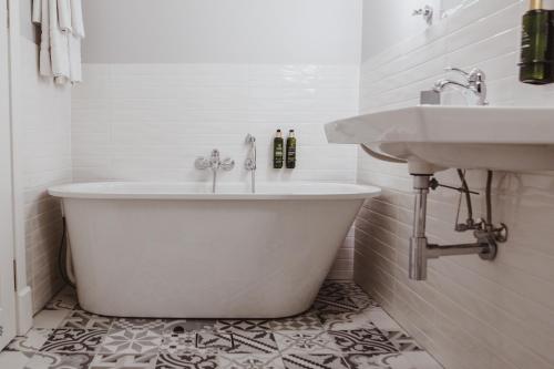 a bathroom with a tub and a sink at Vila Komoda in Palanga